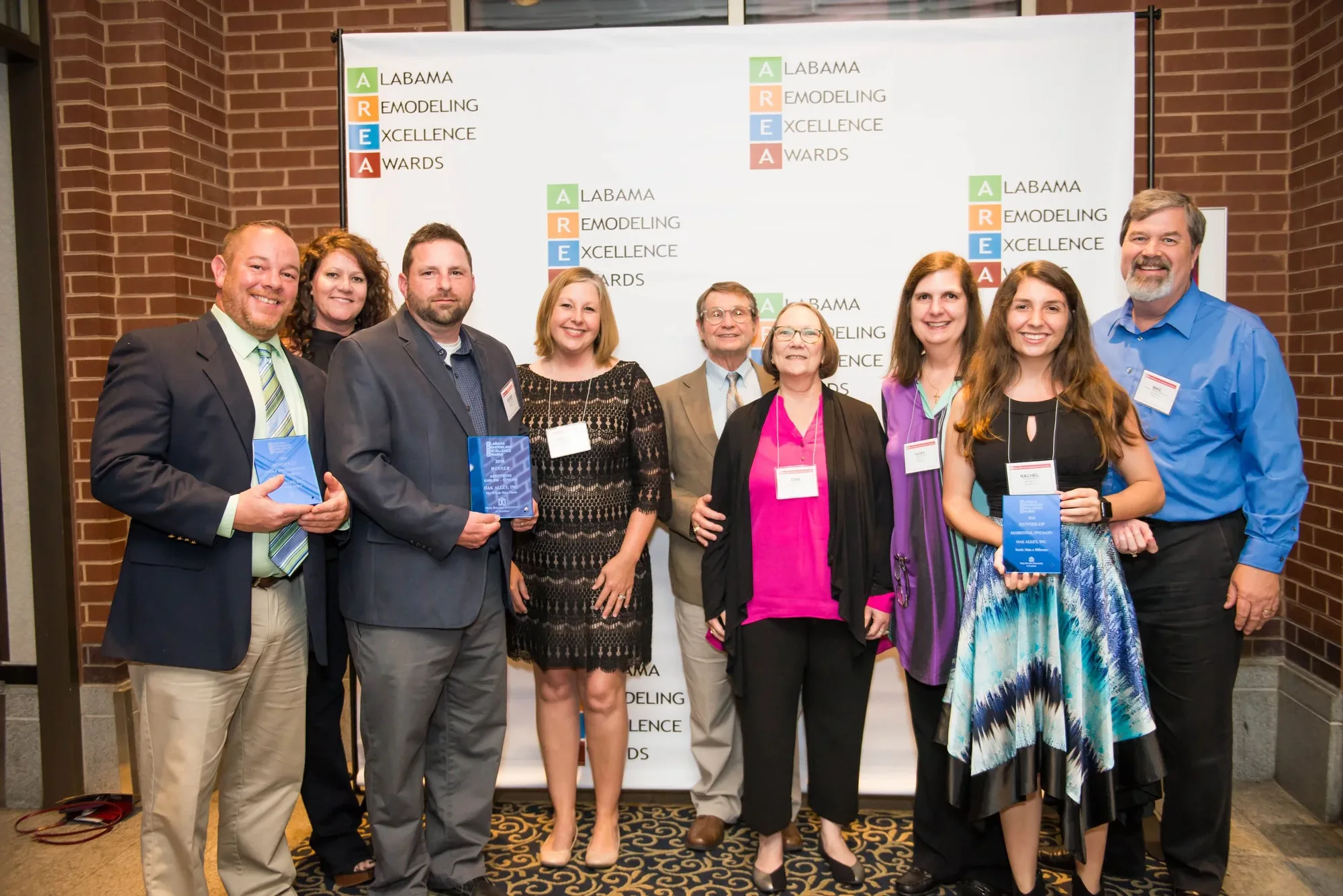 The Oak Alley team holding awards at an Alabama Remodeling Excellence Awards event.